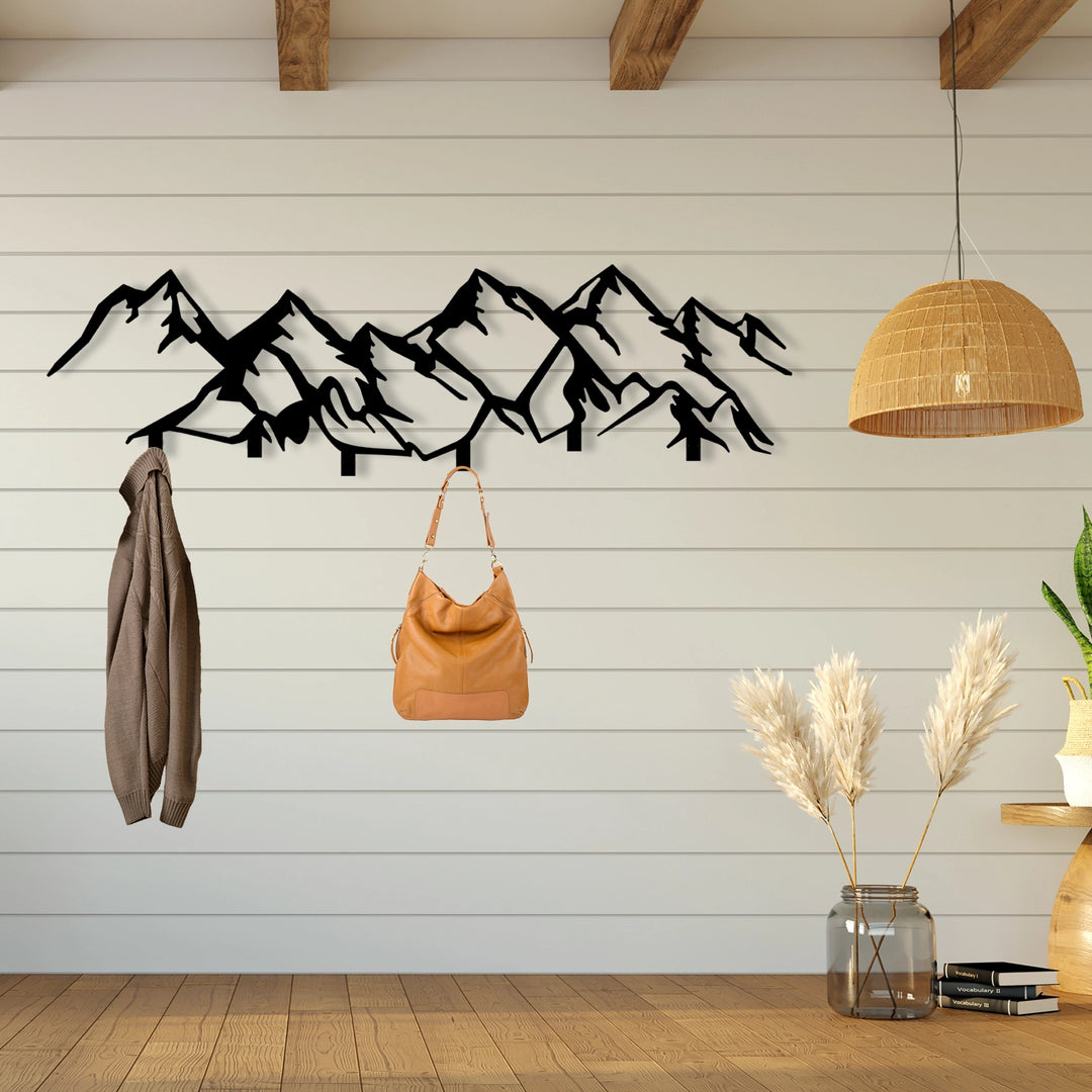 Wall-mounted mountain-themed coat rack with hooks for storage.